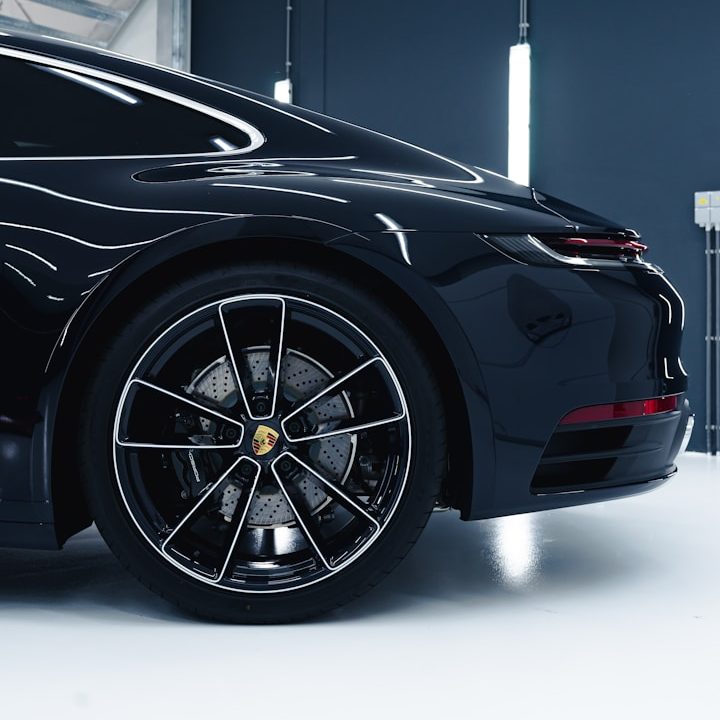 A black Porsche with sleek lines and detailed alloy wheels.