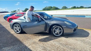 Chris getting into a Porsche Cayman at a Truxton